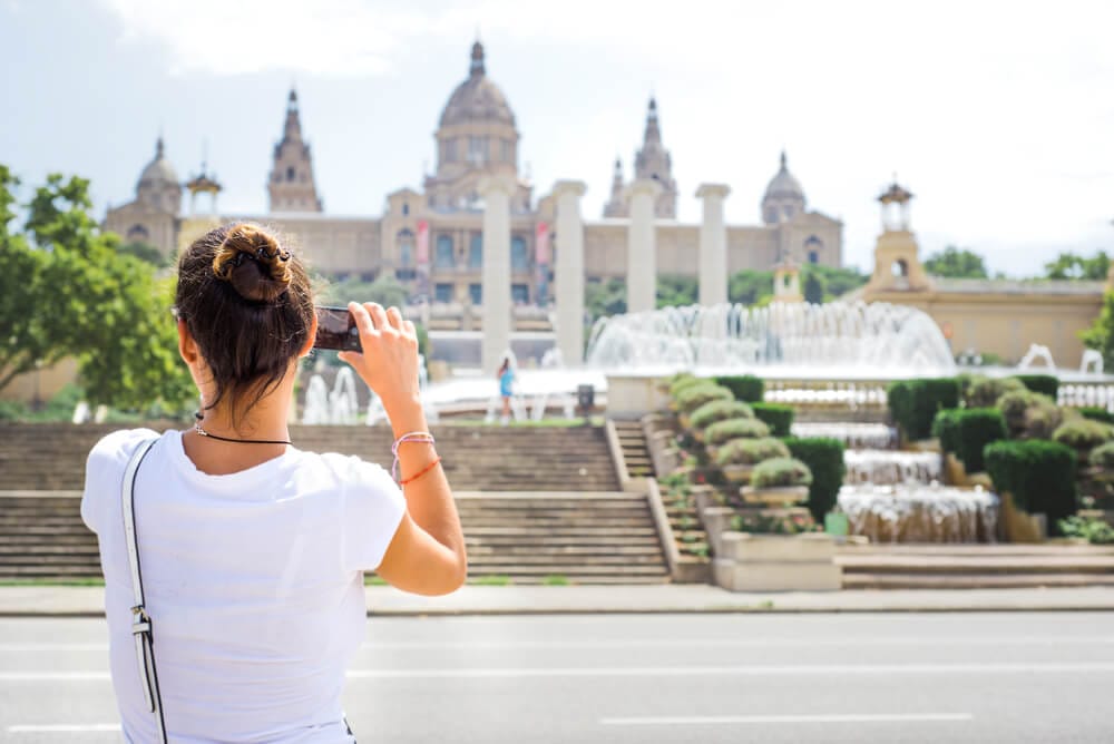 A woman photographing a grand plaza in Barcelona during her private tour of the Barcelona.